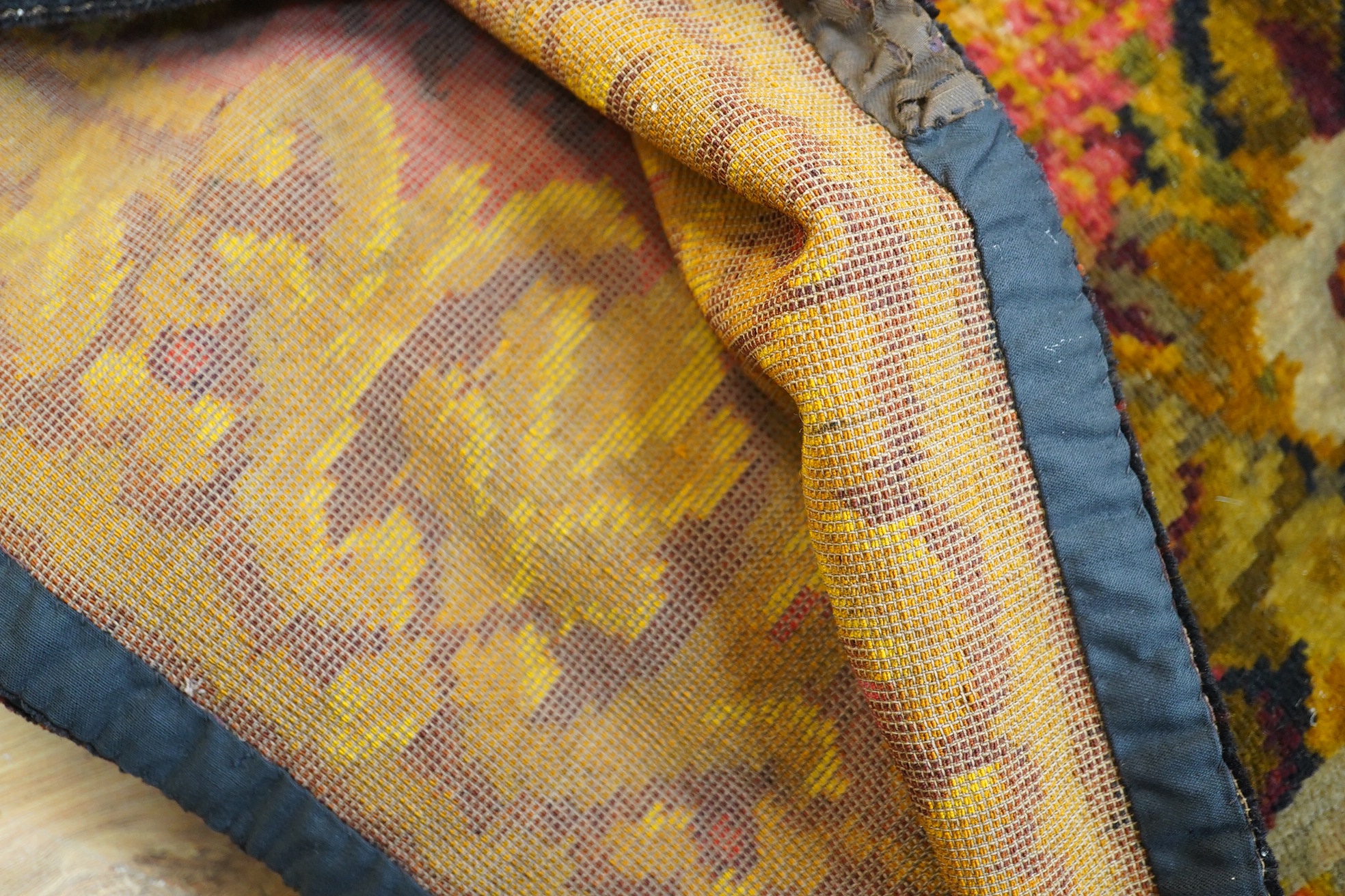 An Edwardian table cover in brightly coloured wools, with a floral design, together with a later 20th century continental grey, beige and cream patterned silk cover, Edwardian table cover 220cm x 172cm. Condition - colou